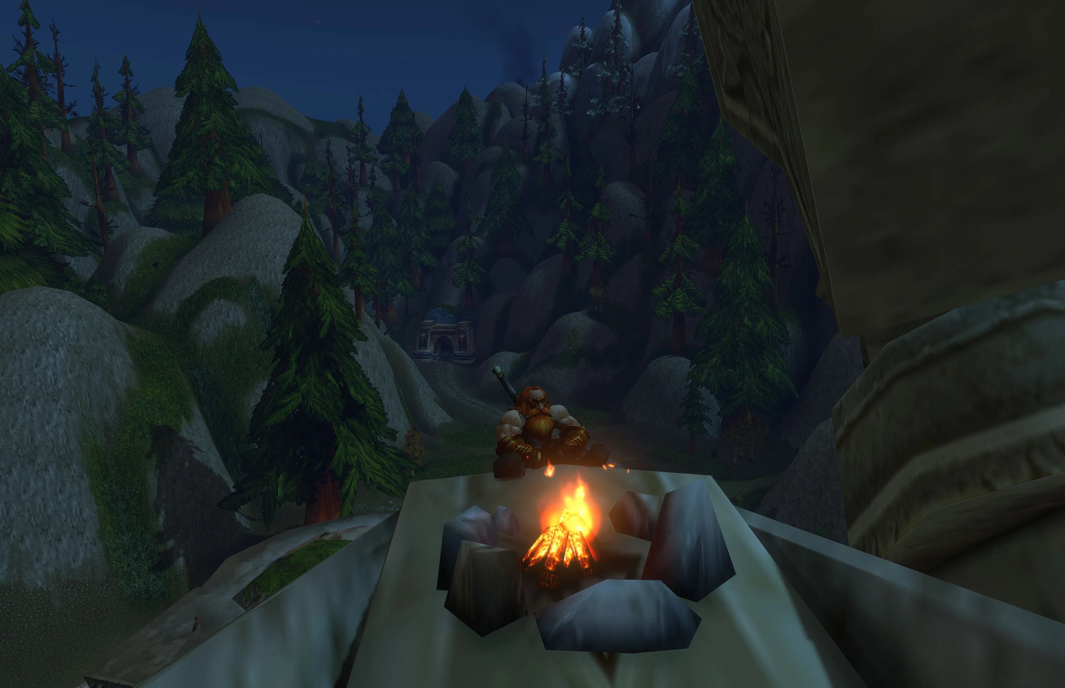 Nuir sitting beside a campfire on top of a statue, with the Valley of Kings behind him.