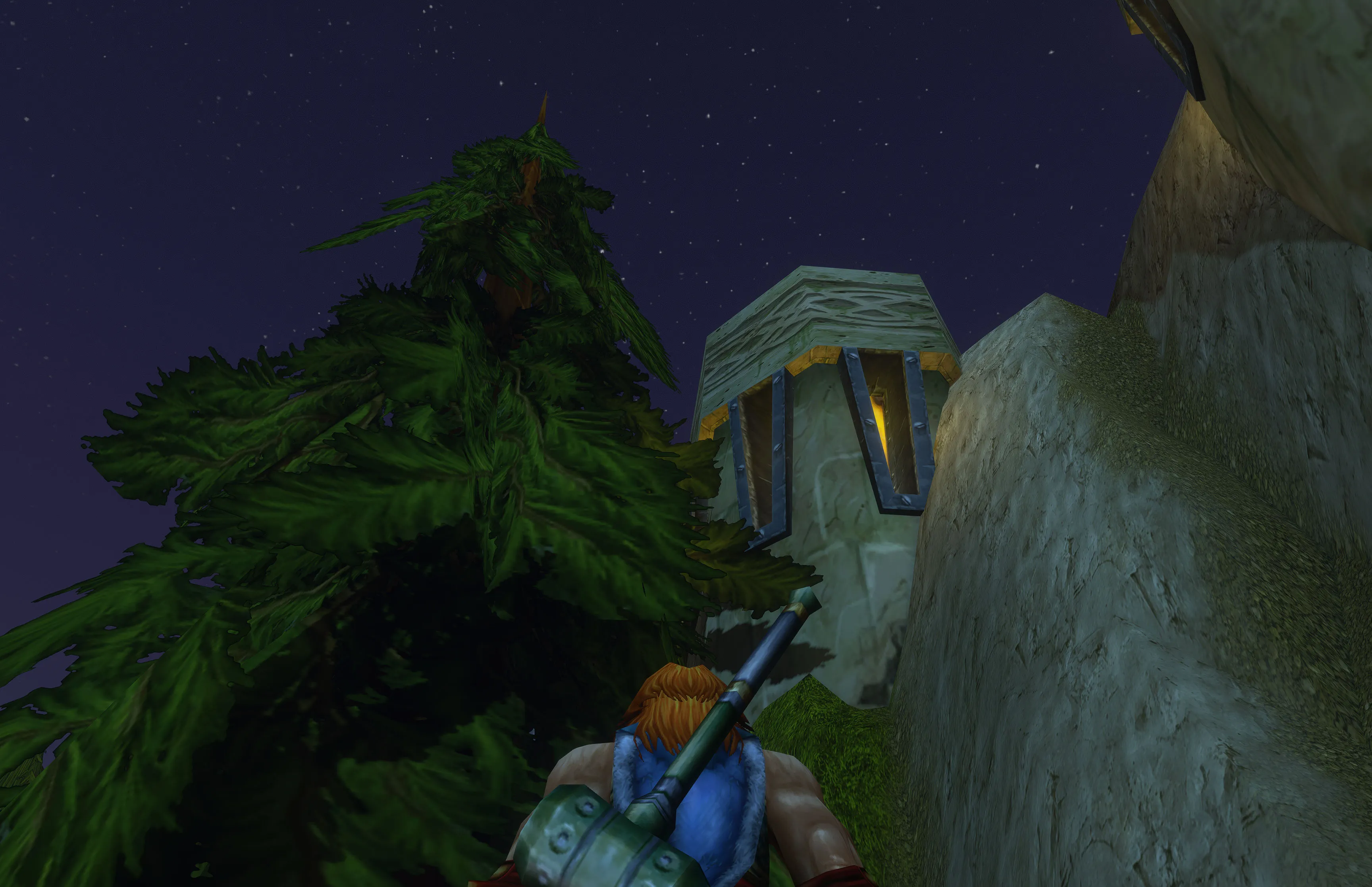 Nuir looking up at a warm window set into the rock, with pines against a starry sky.